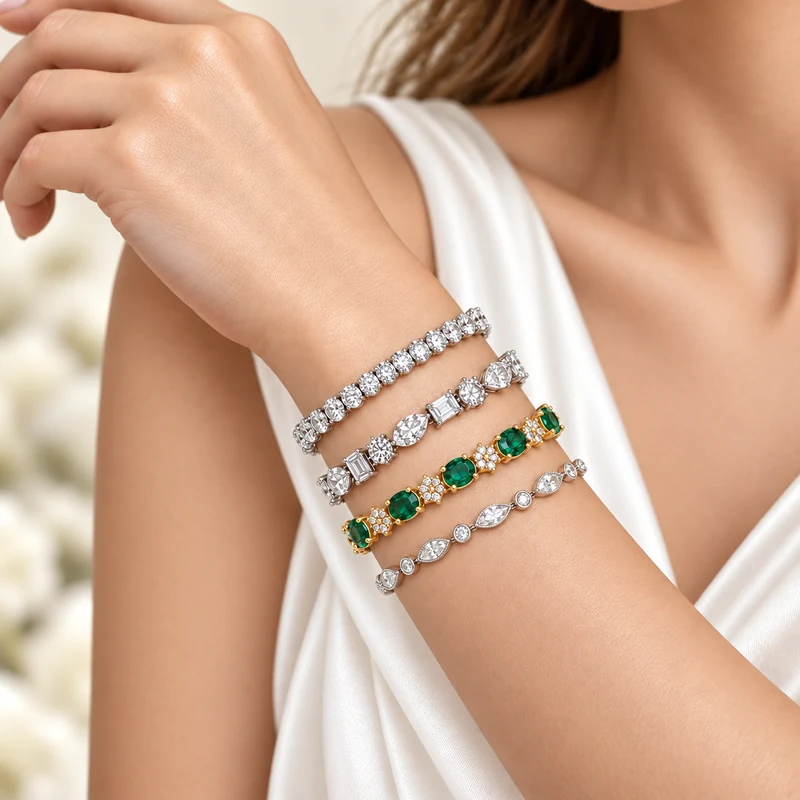 Stacked diamond tennis bracelets in white gold with an emerald and diamond bracelet in yellow gold